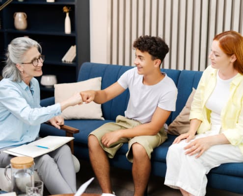 Happy Family Giving Fist Bump To Therapist After Successful Therapy Session