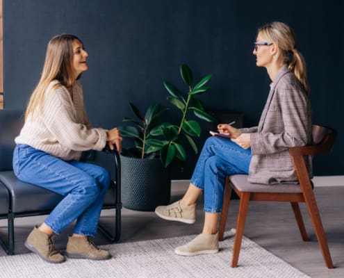 Cheerful Young Woman Patient Has A Casual Conversation With A Consultant Psychologist In The Office.