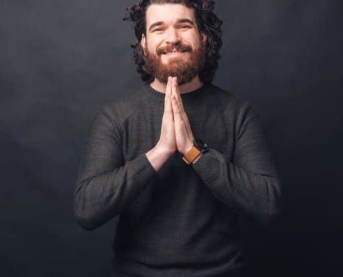 A Picture Of A Man Pleasing And Looking At The Camera Near A Black Wall