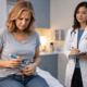 Woman demonstrating a self-injection with a medication pen while a healthcare provider observes and takes notes in a clinical exam room.